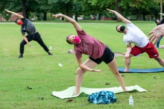 Students practice yoga on Old Main Lawn